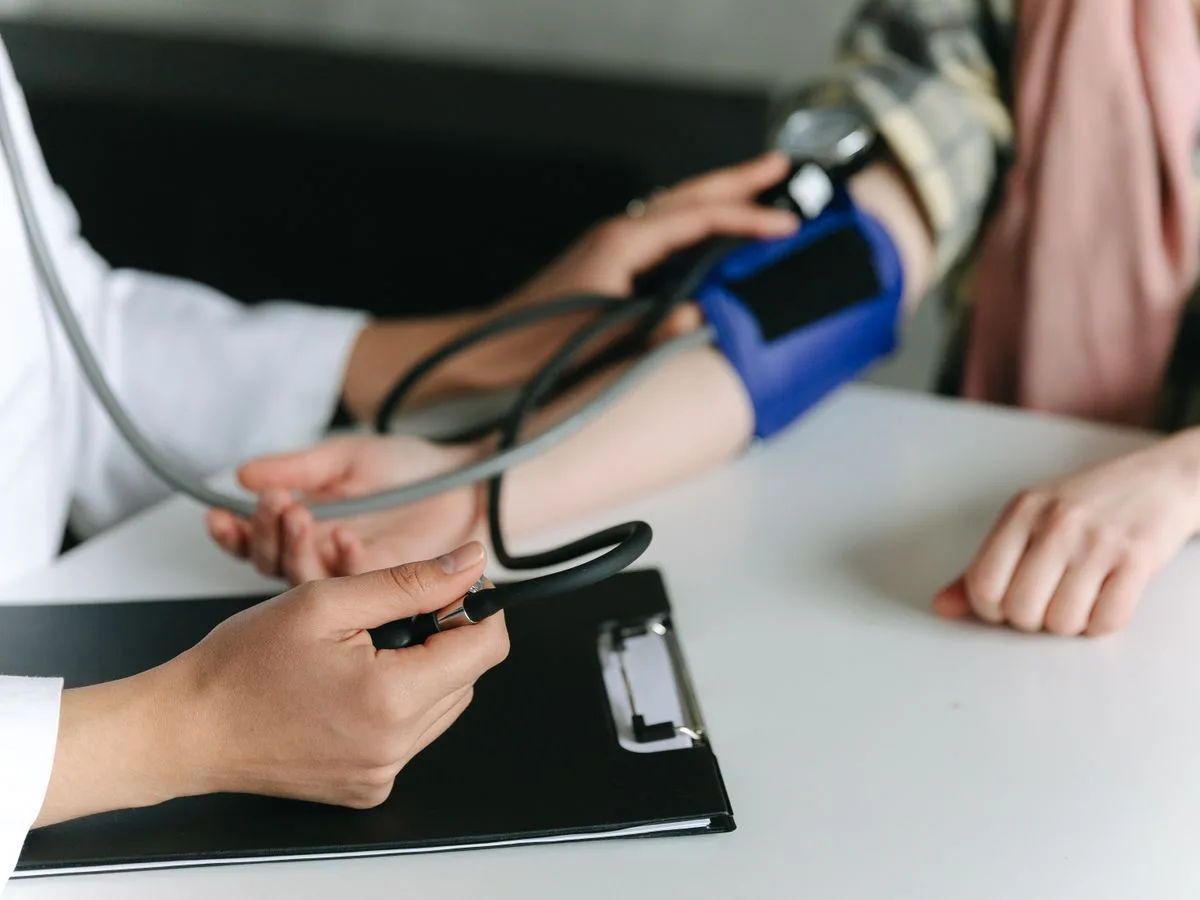 A care professional checking a client’s blood pressure